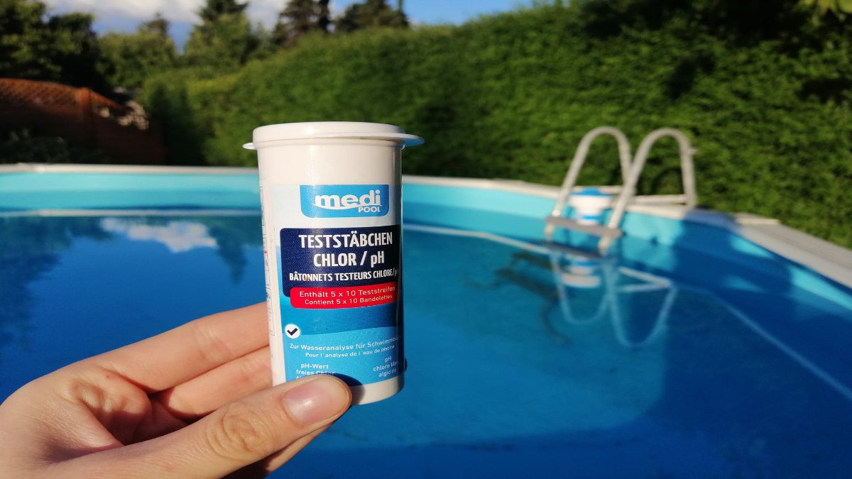 Eine Dose Chlor vor einem Pool.