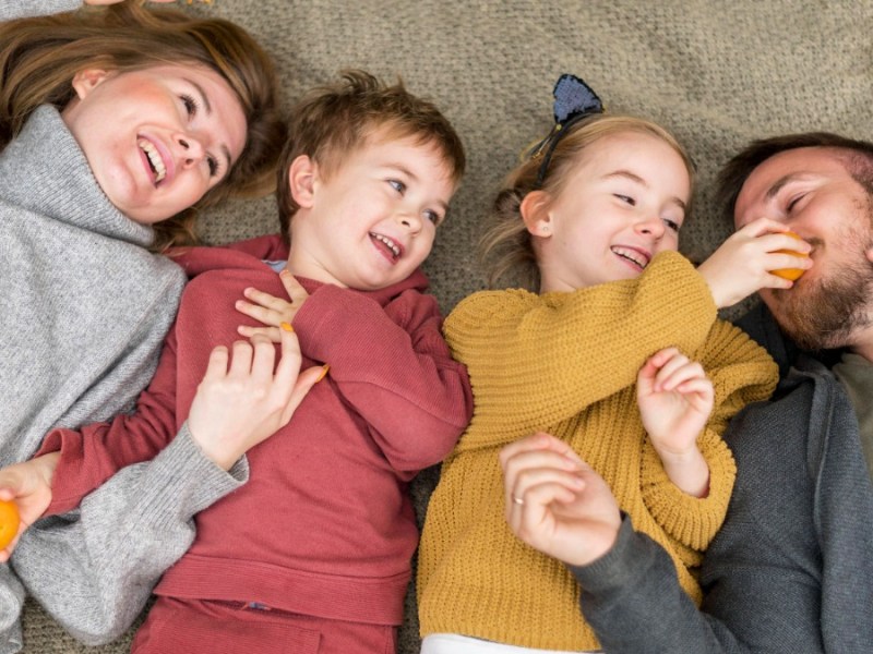 eine glückliche Familie liegt auf dem Boden