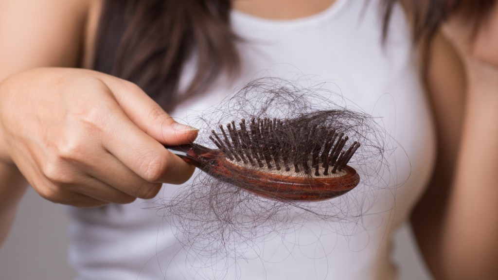 Eine Haarbürste mit vielen Haaren darin.