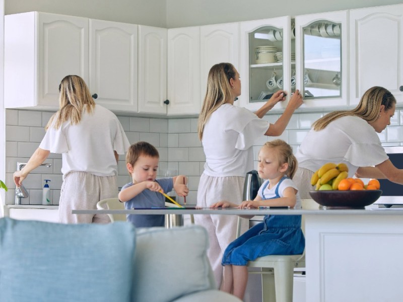 Mutter macht im Hintergrund Hausarbeit während die Kinder im Vordergrund essen