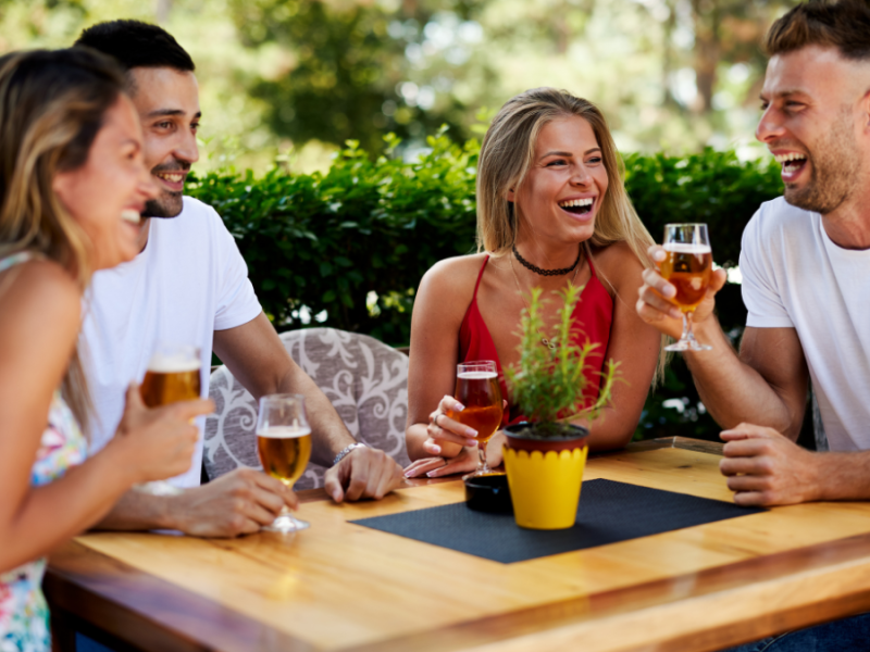 Ein paar Personen sitzen an einem Tisch und trinken kalte Getränke.