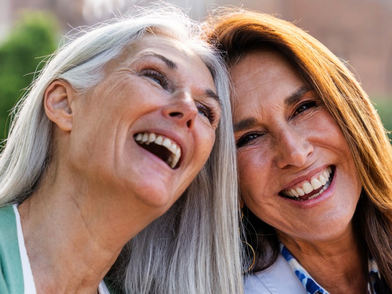 Zwei Frauen über fünfzig lachen miteinander.