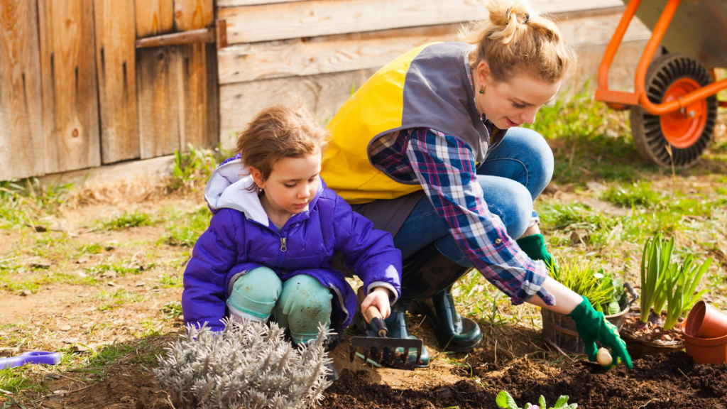 Mutter und Tochter machen Gartenarbeit mit Handschuhen.