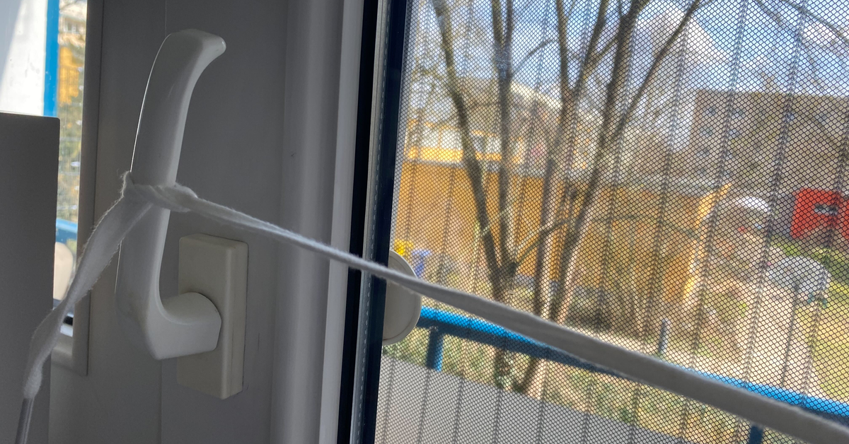 Ein Schnürsenkel, der an einen Fenstergriff angebunden ist.