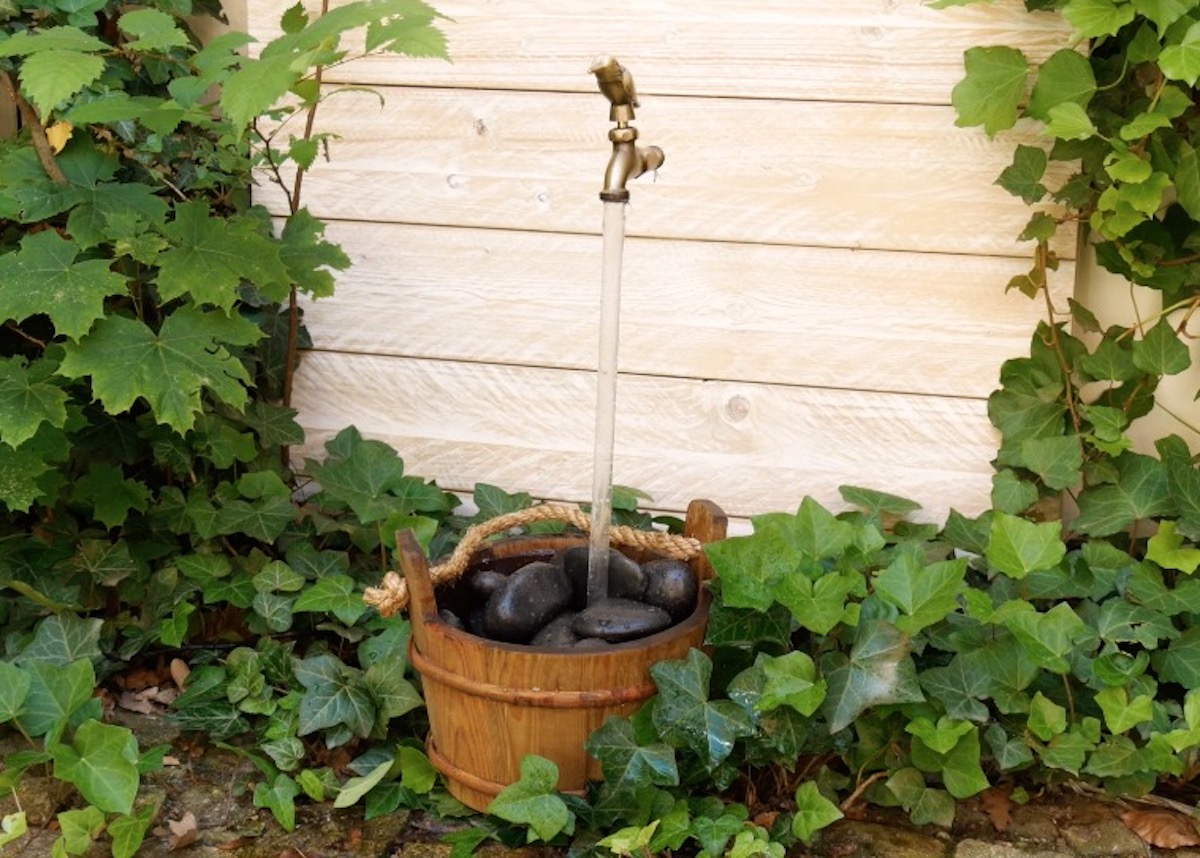 Brunnen mit Steinen und einem schwebenden Wasserhahn