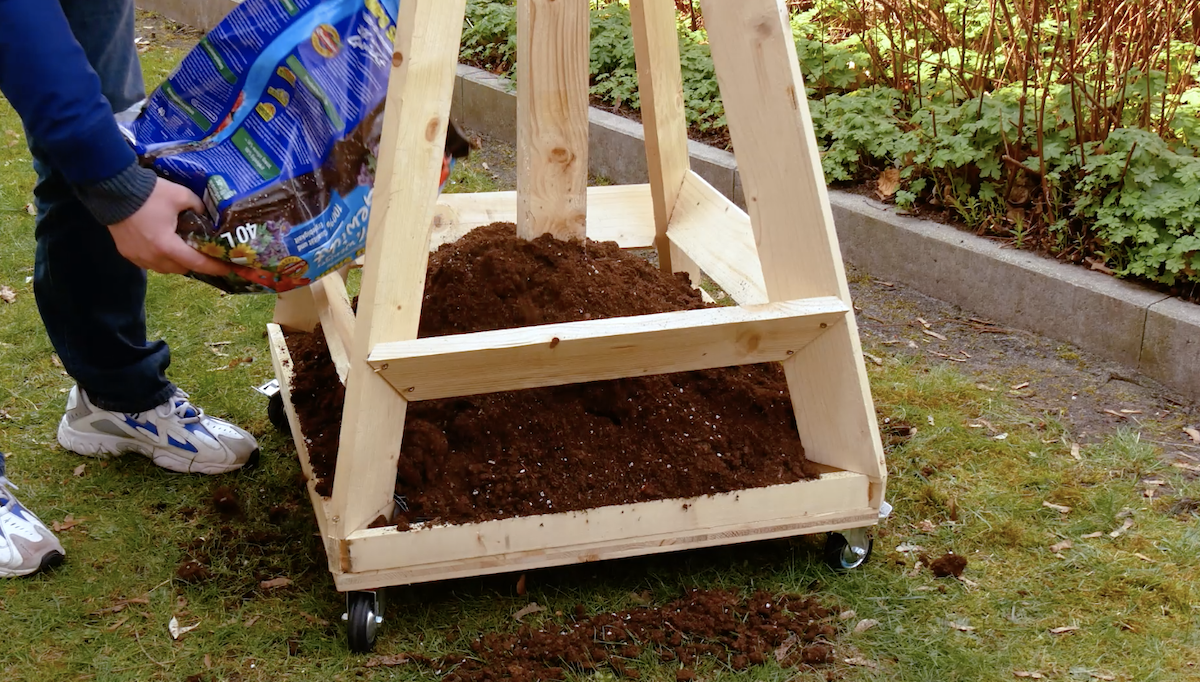 Ein vertikaler Garten wird mit Erde befüllt.