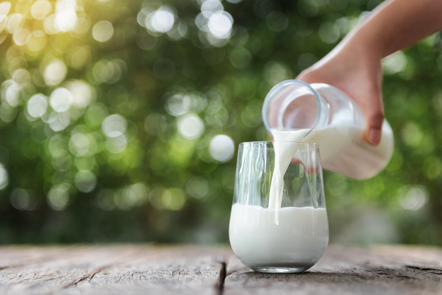 Milch wird in ein Glas geschüttet