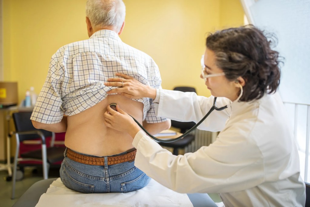 Ärztin untersucht einen älteren Patient.