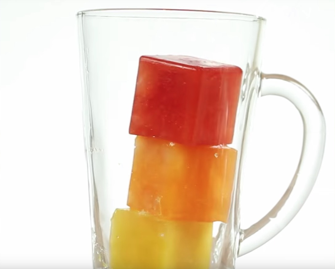 3 bunte EiswÃ¼rfel in einem Glas sorgen in einem heiÃŸen Sommer fÃ¼r AbkÃ¼hlung.