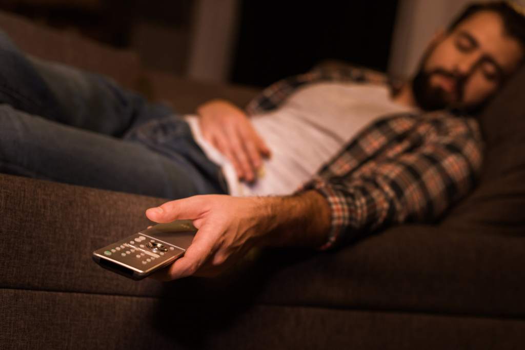 Jemand ist auf der Couch vor dem Fernseher eingeschlafen.