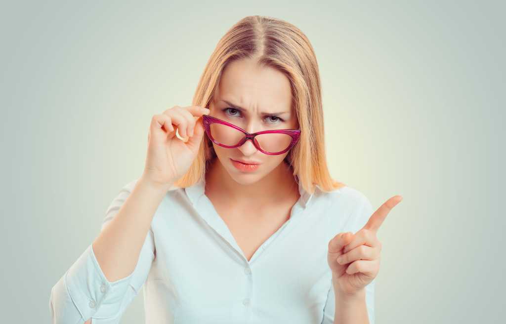 Frau guckt kritisch durch ihre Brille