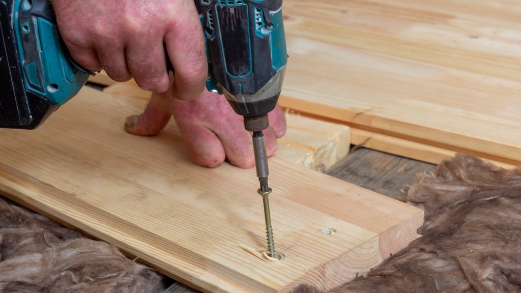 Jemand bohrt in ein Stück Holz.