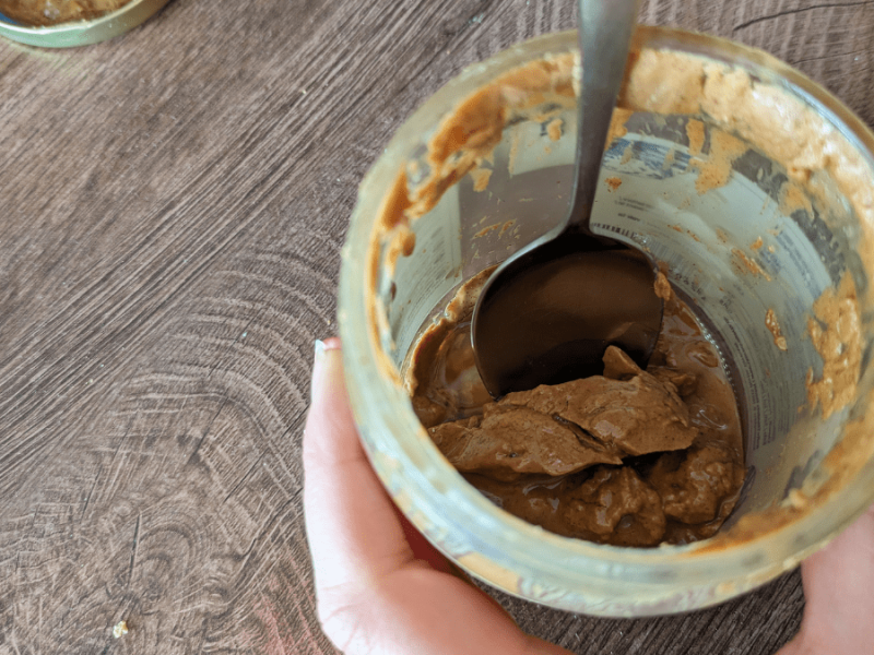 Mandelmus wird mit einem Löffel aus einem Glas gelöffelt.