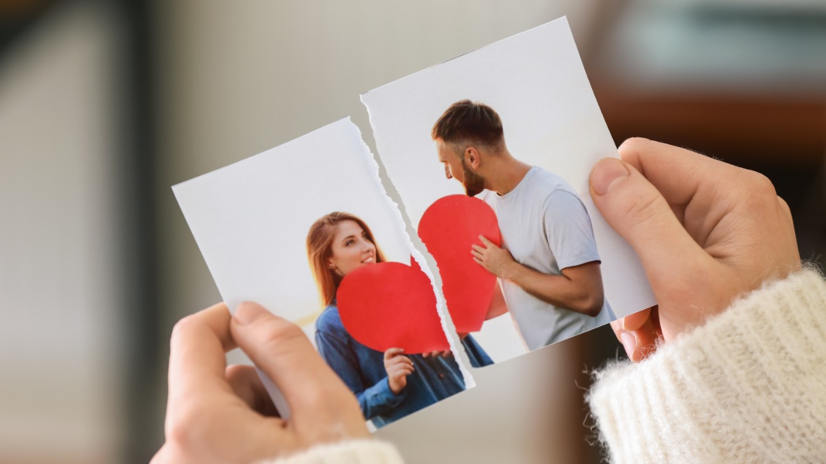 Frau hält ein zerrissenes Foto mit einem Liebespaar in der Hand