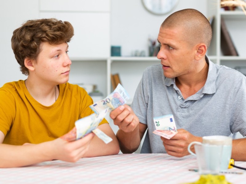 Teenager Sohn gibt seinem Vater Geld