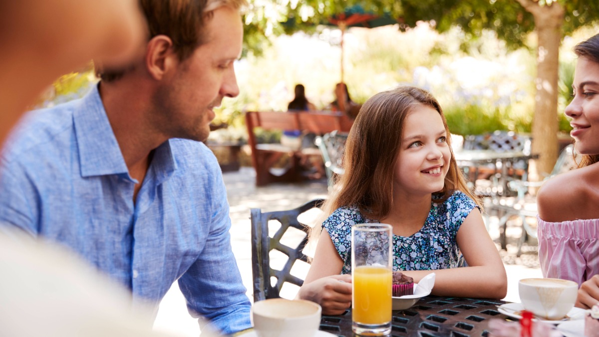 Eine Familie sitzt am Tisch mit Kaffee und Kuchen