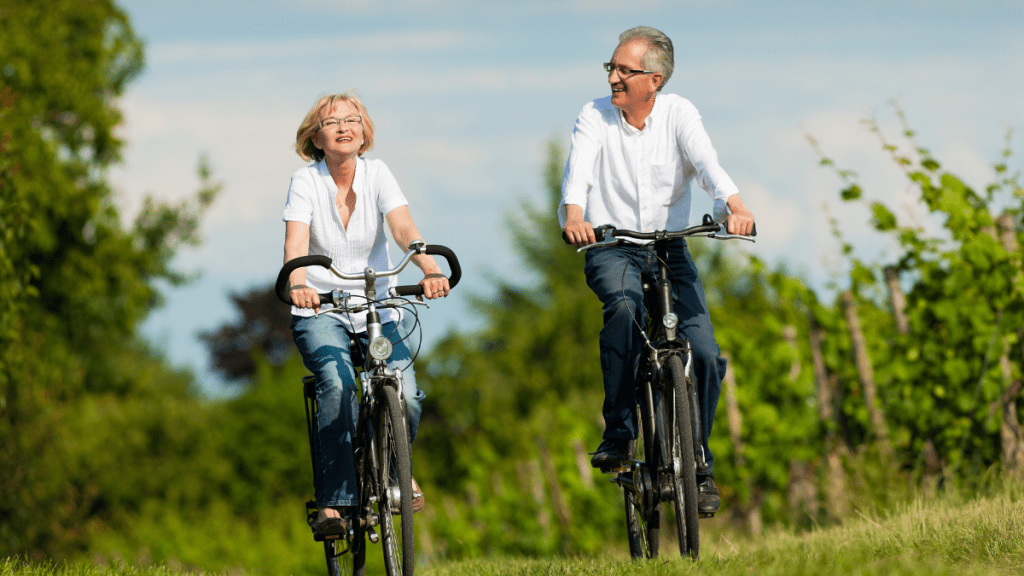 Eine mittelaltes heterosexuelles Pärchen fährt gemeinsam Fahrrad.