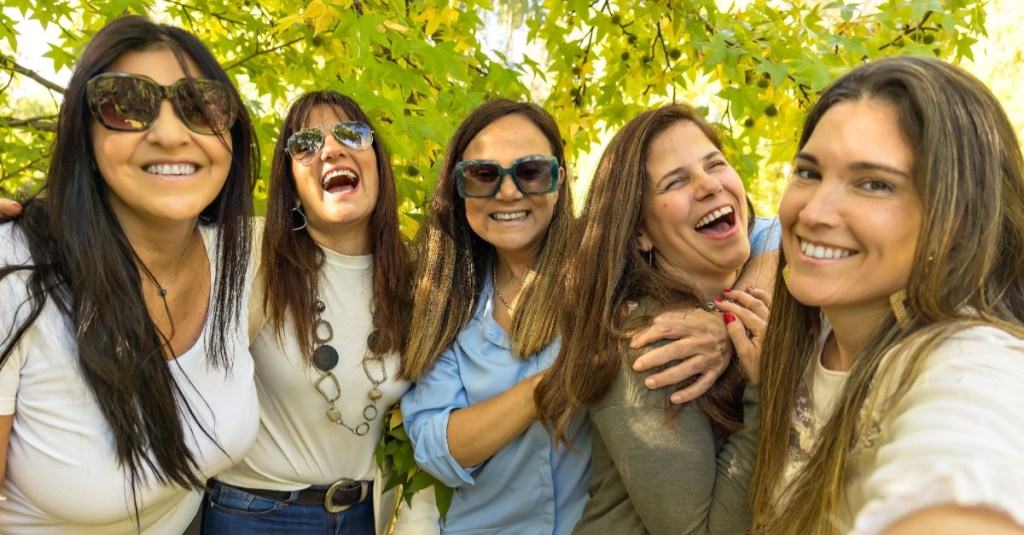 Eine Gruppe von fünf lebhaften Frauen macht ein Selfie an einem sonnigen Tag