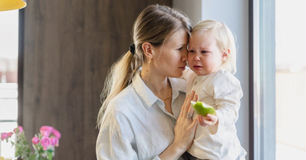 Mutter tröstet trauriges kleines Mädchen