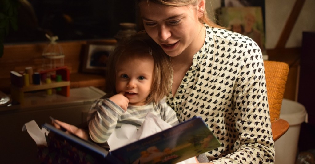 Mutter liest ihrer Tochter abends aus einem Buch vor