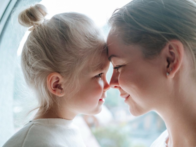 Geschenke fÃ¼r die Kinder: Mutter und Tochter halten ihre Stirn aneinander