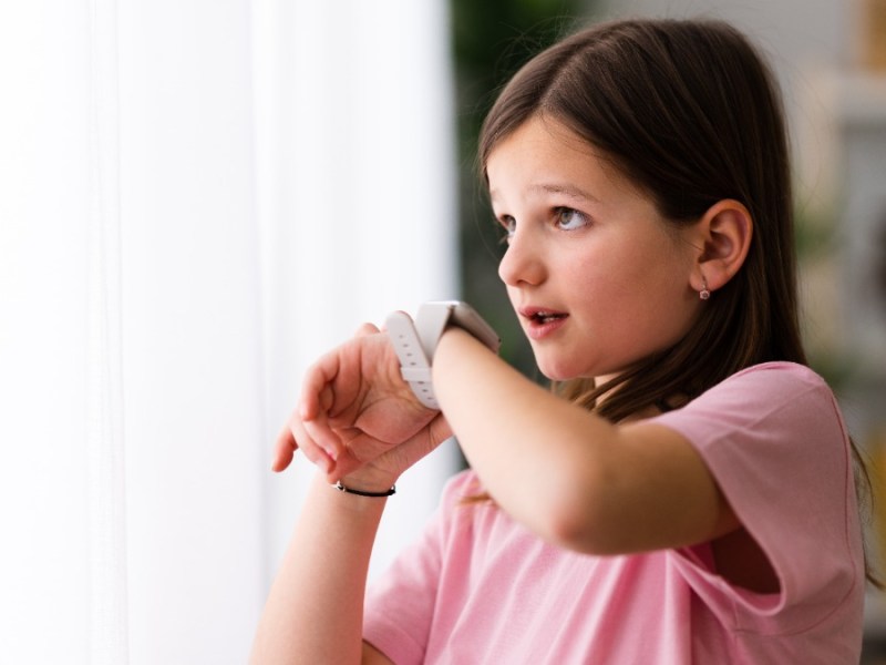 Smartwatch als Geschenk fÃ¼r Kinder: ein junges MÃ¤dchen spricht in eine Smartwatch