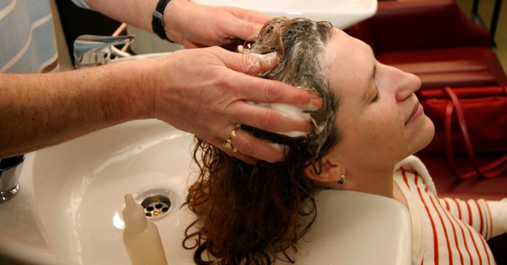 Einer Frau werden beim Friseur die Haare gewaschen