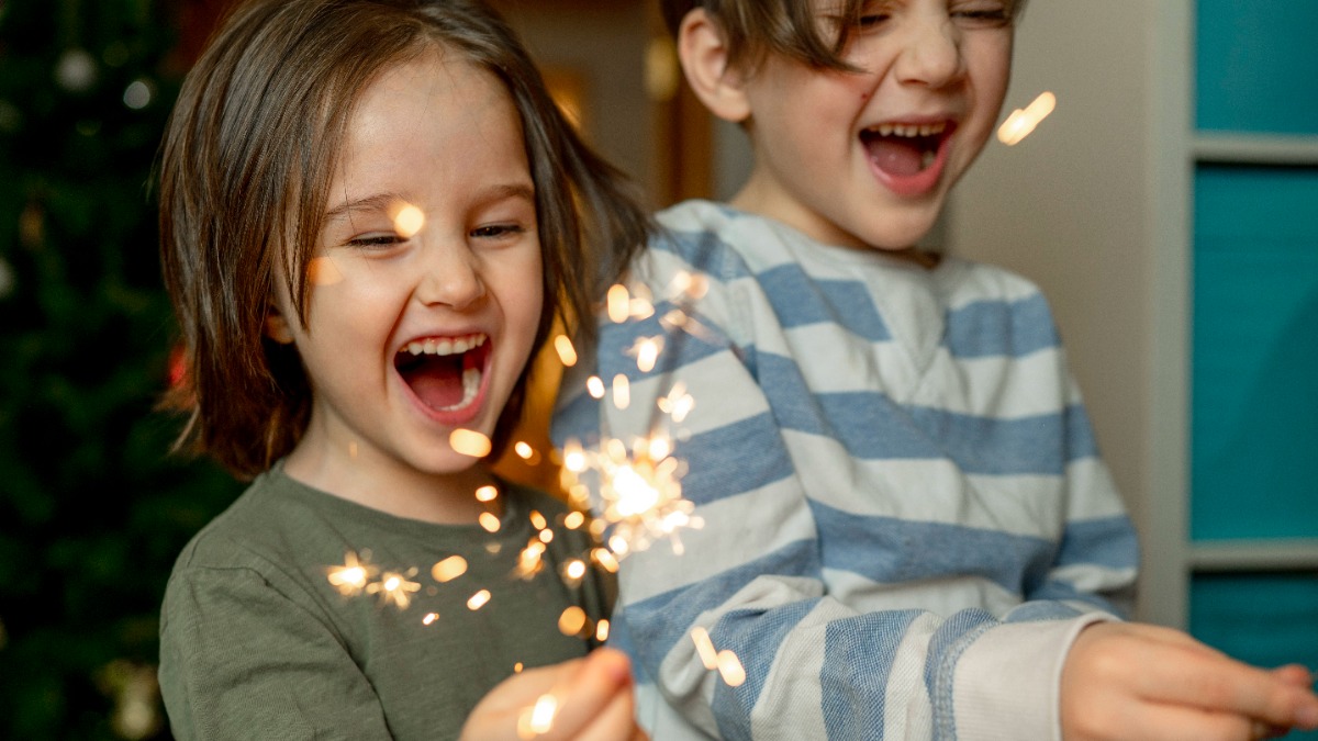 Silvester mit Kind: zwei kleine Jungs halten Wunderkerzen in den Händen