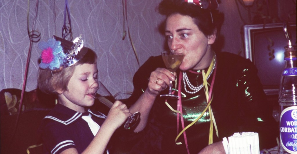 Silvester mit Kindern: eine Frau und ein Kind trinken an Silvester aus einem Glas