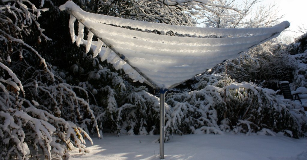 Wäsche im Winter draußen trocknen: ein Wäscheständer ist unter einer Eisdecke versteckt