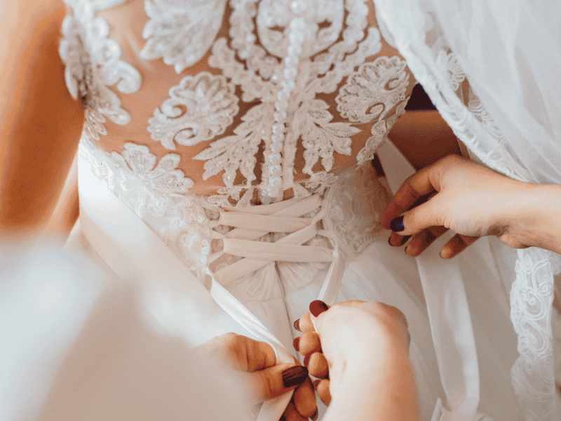 Getting ready Hochzeit, Brautkleid wird zugebunden